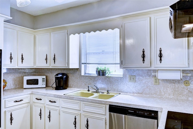 kitchen with white microwave, a sink, light countertops, tasteful backsplash, and stainless steel dishwasher