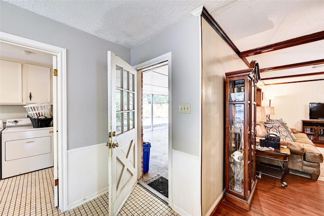 hall featuring washer / dryer, a wainscoted wall, and a textured ceiling