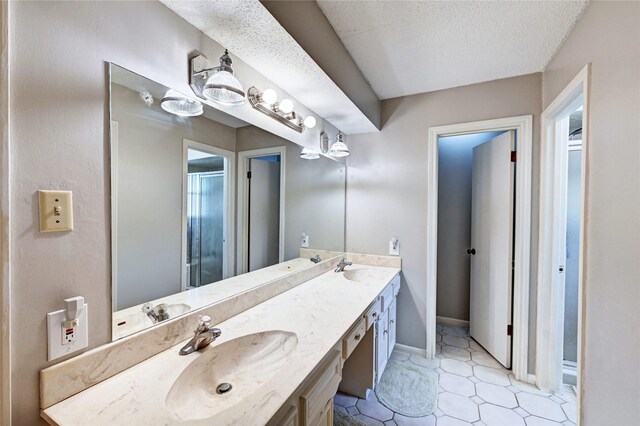 bathroom with a sink, a shower stall, and double vanity