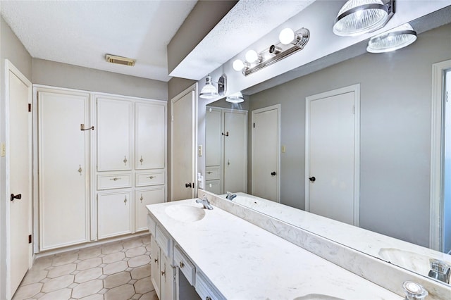 full bath with a sink, double vanity, and visible vents