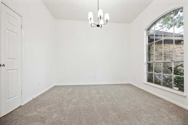 carpeted empty room with baseboards and a notable chandelier