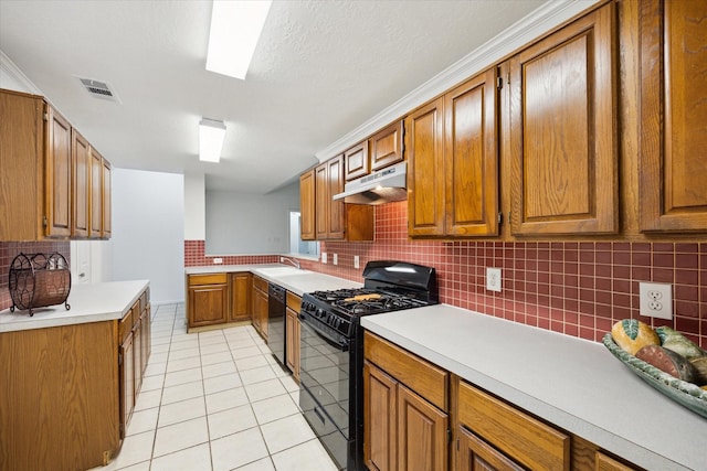 kitchen featuring brown cabinets, decorative backsplash, under cabinet range hood, visible vents, and black appliances
