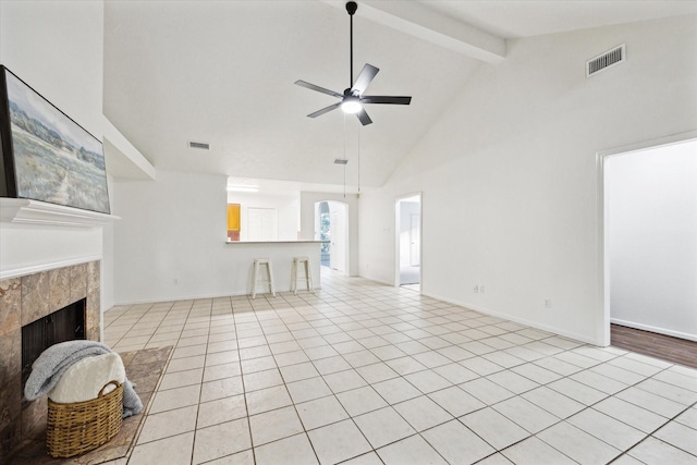 unfurnished living room featuring a ceiling fan, beamed ceiling, visible vents, and a tile fireplace