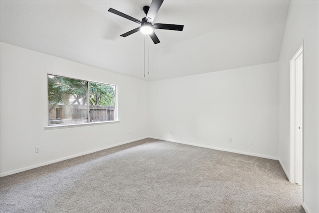 empty room with carpet floors, a ceiling fan, baseboards, and vaulted ceiling