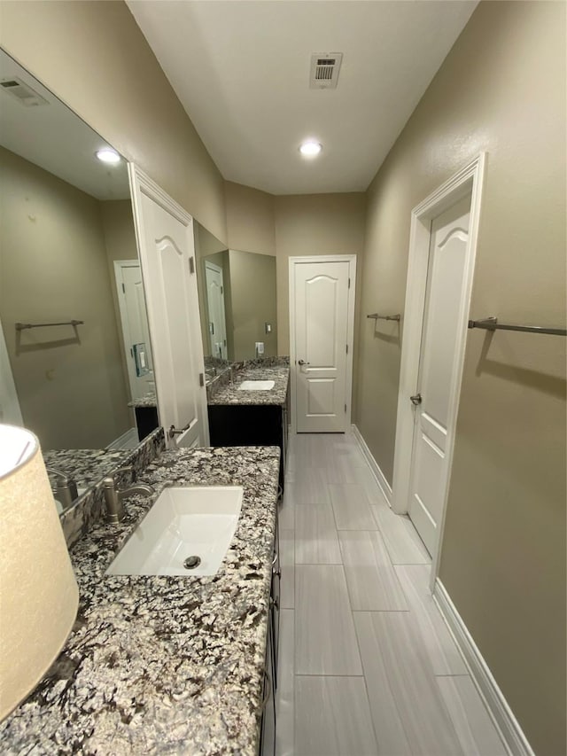 full bath with a sink, two vanities, recessed lighting, and visible vents