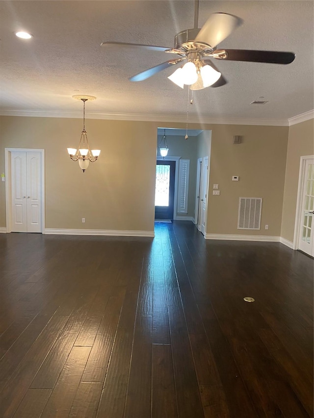 spare room featuring visible vents, crown molding, baseboards, dark wood-style floors, and ceiling fan with notable chandelier