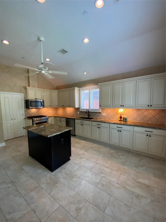 kitchen featuring a sink, lofted ceiling, tasteful backsplash, and stainless steel appliances
