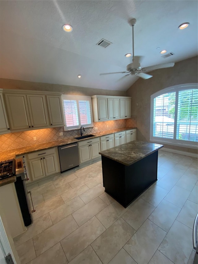 kitchen with backsplash, dishwasher, vaulted ceiling, and a wealth of natural light