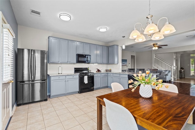 kitchen featuring visible vents, pendant lighting, black appliances, and ceiling fan with notable chandelier
