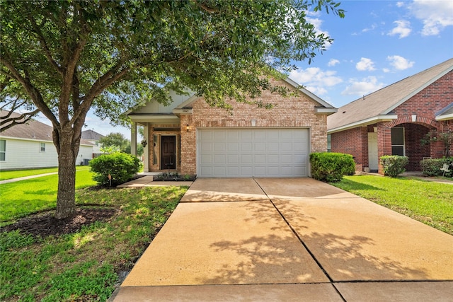 view of front of property with concrete driveway, an attached garage, a front yard, and brick siding