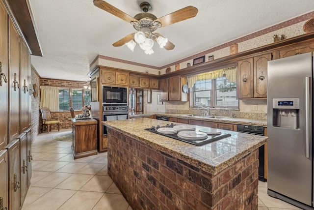 kitchen featuring a ceiling fan, light tile patterned flooring, a kitchen island, a sink, and black appliances