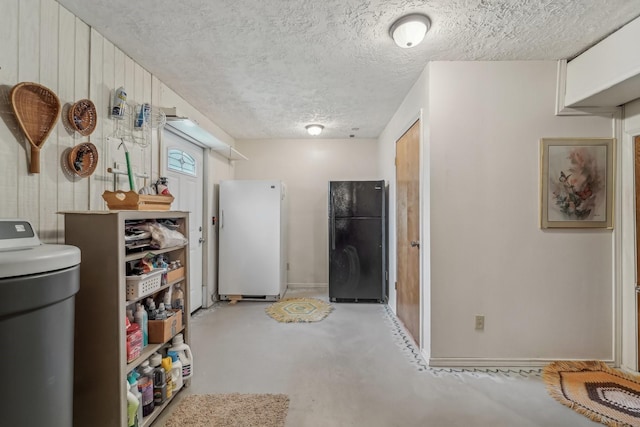 interior space with a textured ceiling, baseboards, and finished concrete flooring