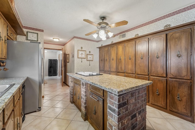 kitchen featuring visible vents, freestanding refrigerator, light tile patterned flooring, a kitchen island, and ceiling fan