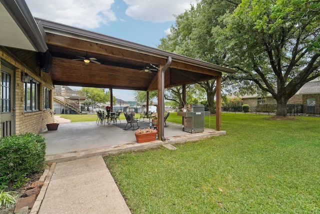 view of yard with fence, ceiling fan, and a patio area