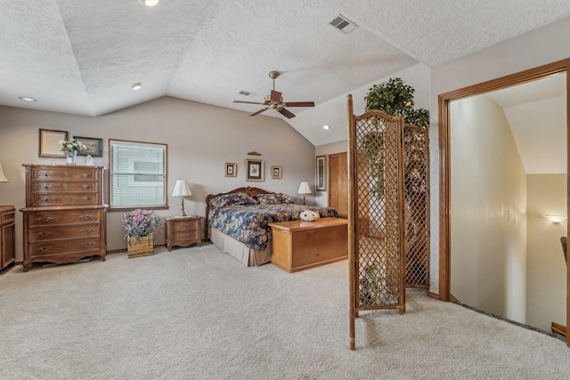 carpeted bedroom with a textured ceiling, vaulted ceiling, ceiling fan, and visible vents