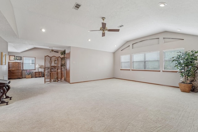 interior space featuring visible vents, a ceiling fan, lofted ceiling, and carpet flooring