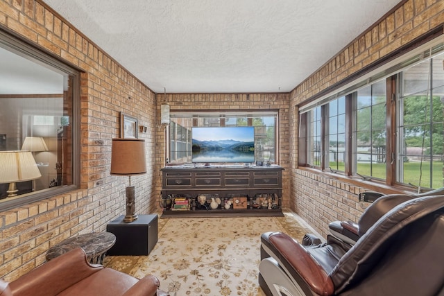living room with a textured ceiling and brick wall