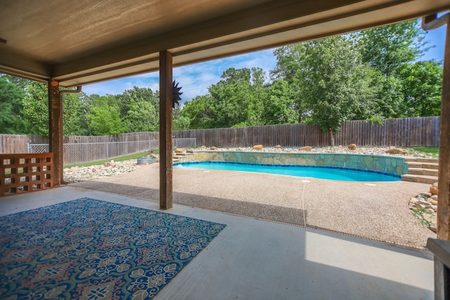 view of swimming pool featuring a fenced backyard, a fenced in pool, and a patio