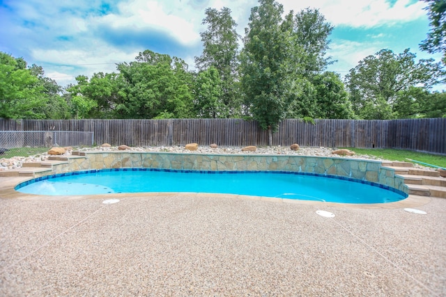 view of swimming pool with a fenced in pool, a fenced backyard, and a patio