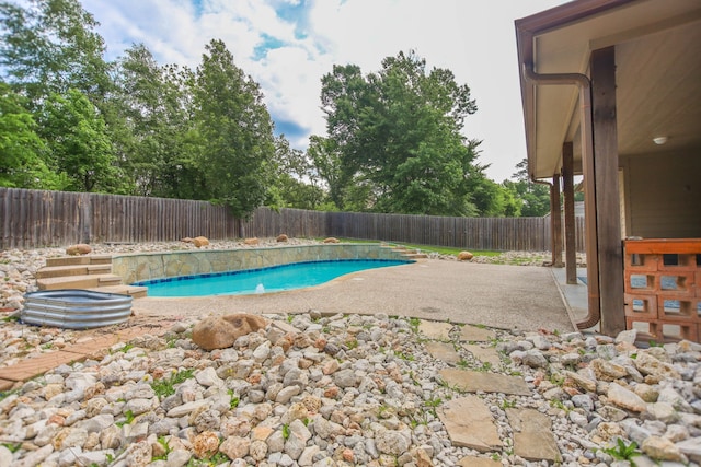 view of swimming pool featuring a fenced in pool, a fenced backyard, and a patio area