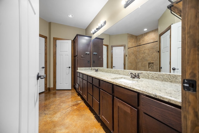 full bathroom with a sink, baseboards, finished concrete flooring, and double vanity