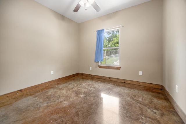 empty room with baseboards, a ceiling fan, and concrete flooring