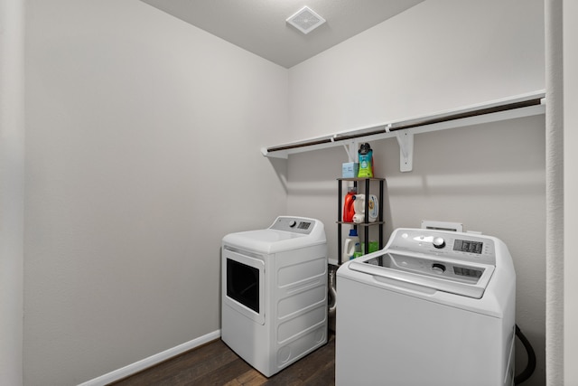 laundry area with baseboards, laundry area, dark wood-style floors, and washer and clothes dryer