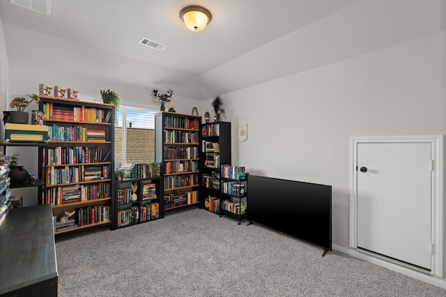 interior space featuring carpet floors, visible vents, and vaulted ceiling
