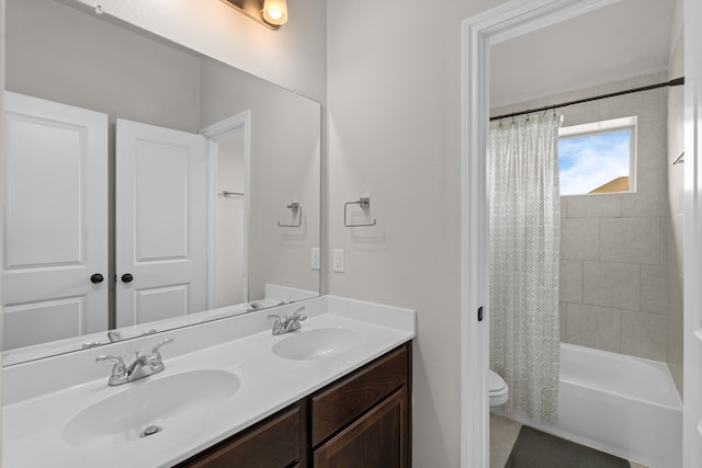 bathroom featuring double vanity, a sink, shower / bathtub combination with curtain, and toilet
