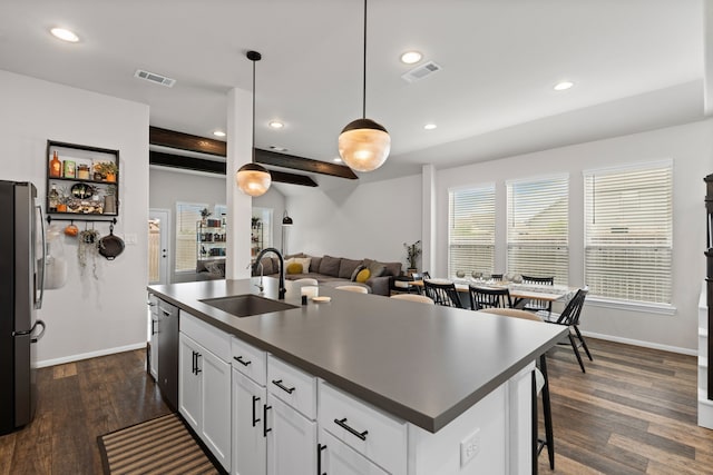 kitchen featuring visible vents, a sink, dark countertops, and stainless steel appliances