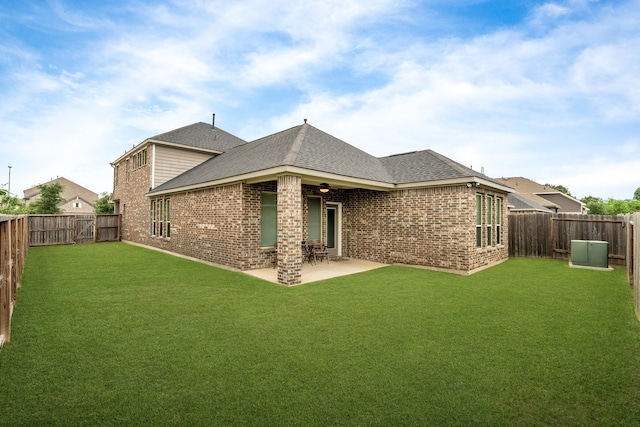 back of house featuring a fenced backyard, a shingled roof, and brick siding
