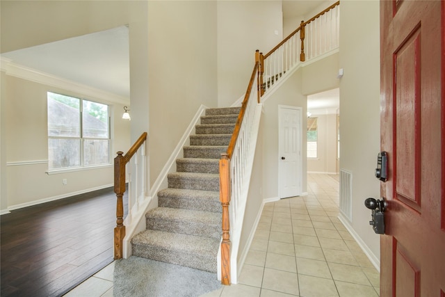 107 Mango St, Lake Jackson, TX 77566 - stairway featuring crown molding, tile patterned flooring, baseboards, a towering ceiling, and visible vents