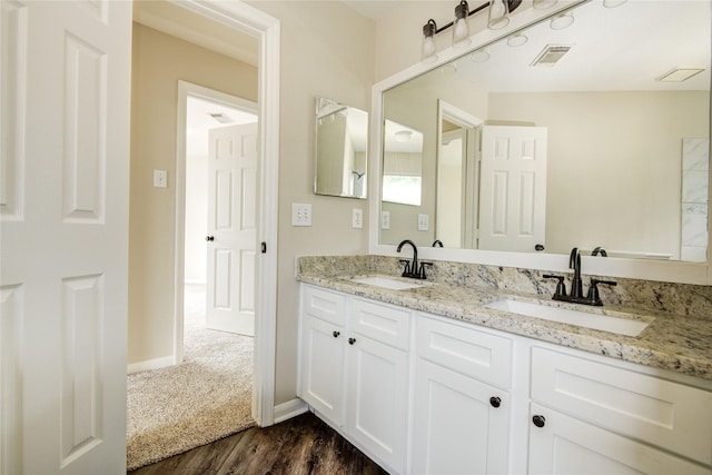 107 Mango St, Lake Jackson, TX 77566 - full bath with visible vents, a sink, wood finished floors, and double vanity