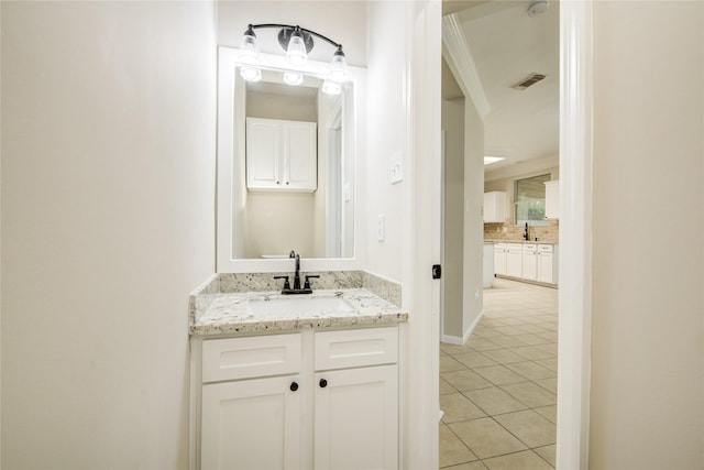 107 Mango St, Lake Jackson, TX 77566 - bathroom featuring visible vents, decorative backsplash, vanity, baseboards, and tile patterned floors