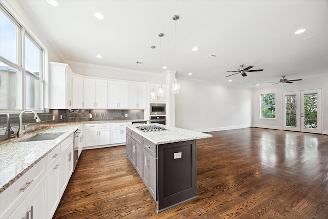 1230 W 25th St Unit C, Houston, TX 77008 - kitchen featuring a center island, a sink, white cabinetry, decorative backsplash, and appliances with stainless steel finishes