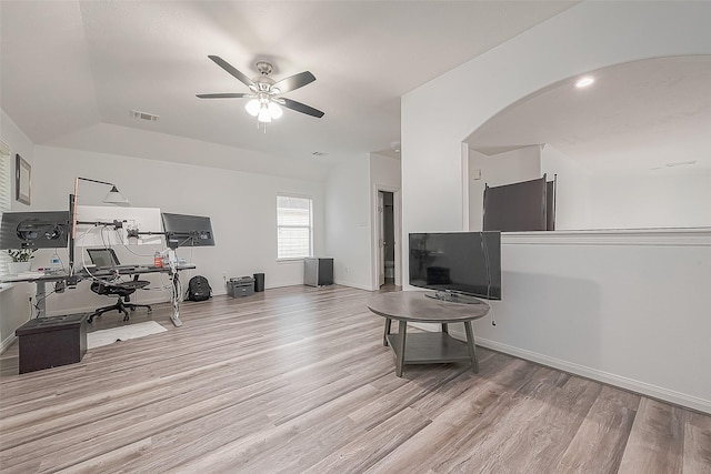 unfurnished living room featuring ceiling fan, arched walkways, baseboards, wood finished floors, and visible vents