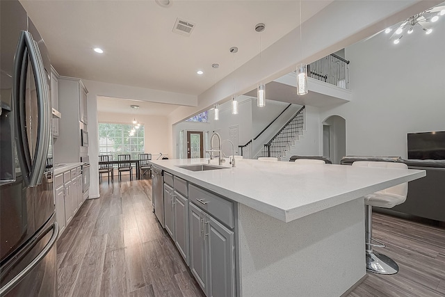 kitchen featuring dark wood-style flooring, visible vents, appliances with stainless steel finishes, gray cabinetry, and a sink