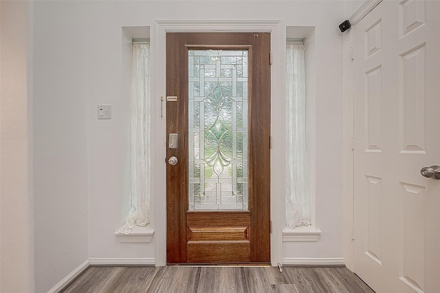 entryway with baseboards and wood finished floors