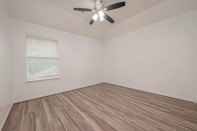 unfurnished room with a ceiling fan, baseboards, vaulted ceiling, and wood finished floors