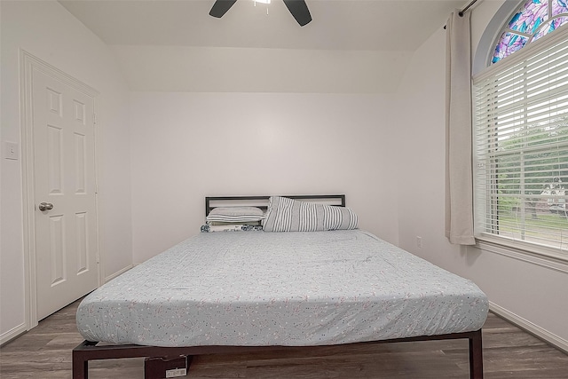 bedroom featuring baseboards, ceiling fan, wood finished floors, and lofted ceiling