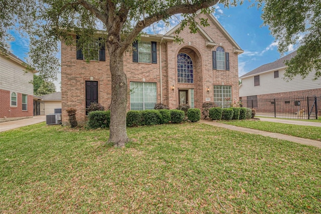view of front of property with fence, central AC, a front lawn, and brick siding