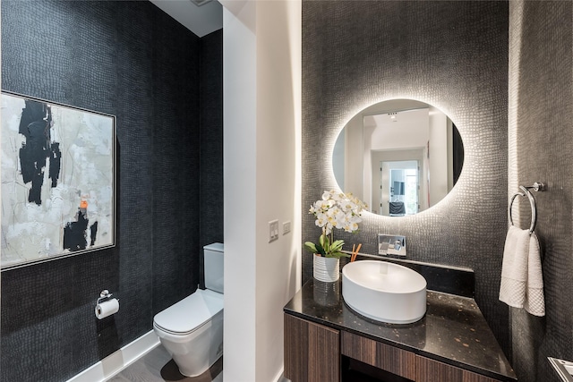 bathroom featuring vanity, backsplash, and toilet