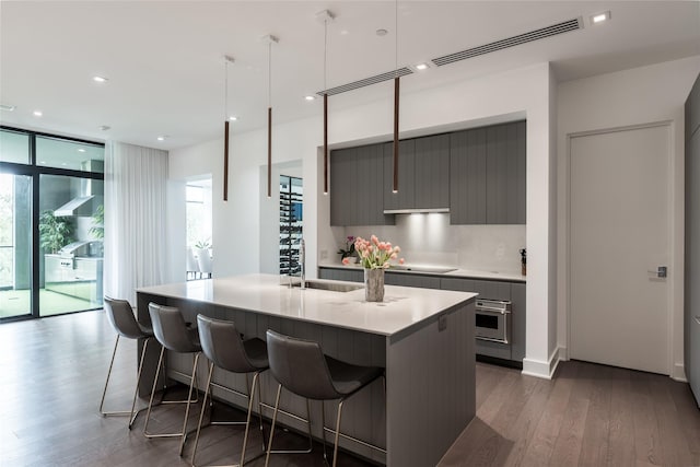 kitchen with a sink, modern cabinets, gray cabinets, and visible vents
