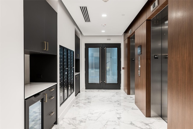 2710 Steel St Unit 301, Houston, TX 77098 - kitchen featuring wine cooler, modern cabinets, elevator, mail area, and light marble finish flooring