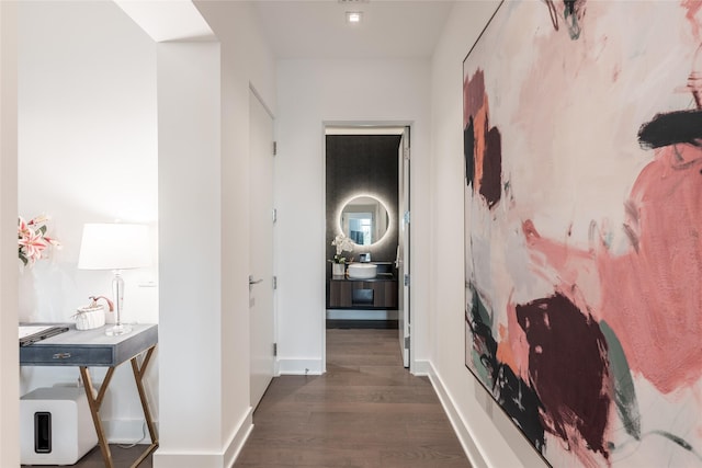 hallway featuring baseboards and dark wood-style flooring