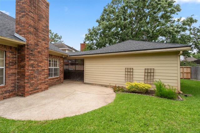 4423 Nassau Dr, Sugar Land, TX 77479 - exterior space featuring fence, a shingled roof, a chimney, a patio area, and a yard