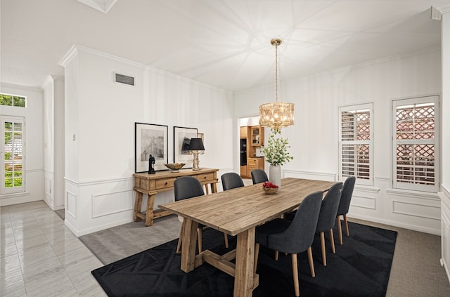 4423 Nassau Dr, Sugar Land, TX 77479 - dining space featuring crown molding, visible vents, an inviting chandelier, and a decorative wall