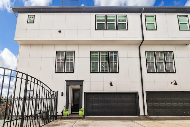 view of front of property featuring an attached garage and fence
