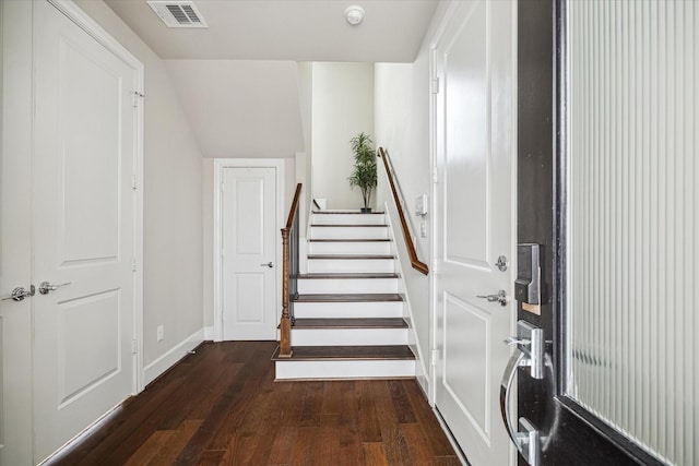 staircase with baseboards, vaulted ceiling, hardwood / wood-style flooring, and visible vents