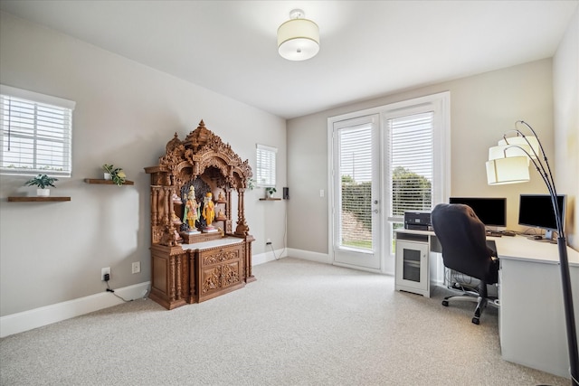 carpeted office space featuring baseboards and plenty of natural light